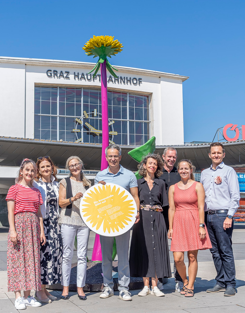 Gruppenfoto am Grazer Hauptbahnhof vor Löwenzahn-Skulptur von Künstler Thomas Stimm