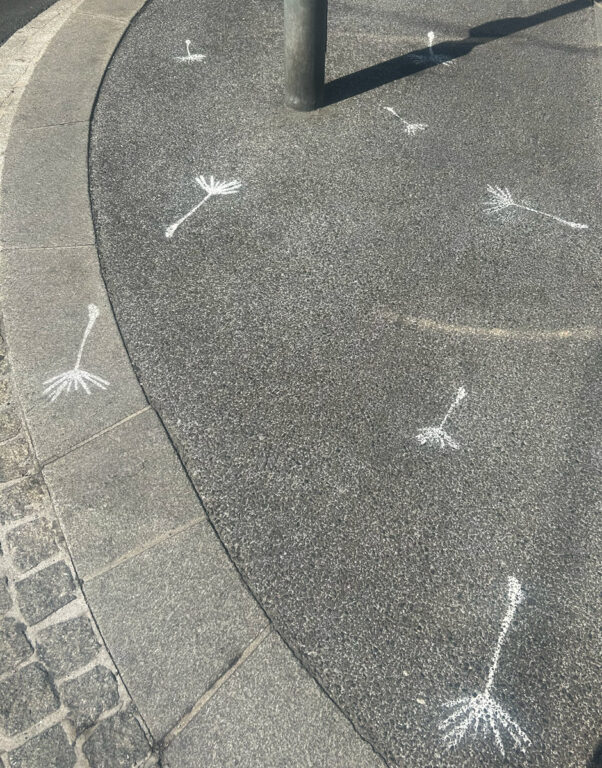 Flugschirmchen mit Kreide auf Asphalt gesprayt