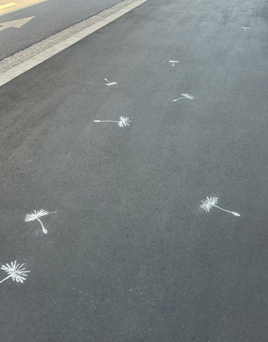 Flugschirmchen mit Kreide auf Asphalt gesprayt