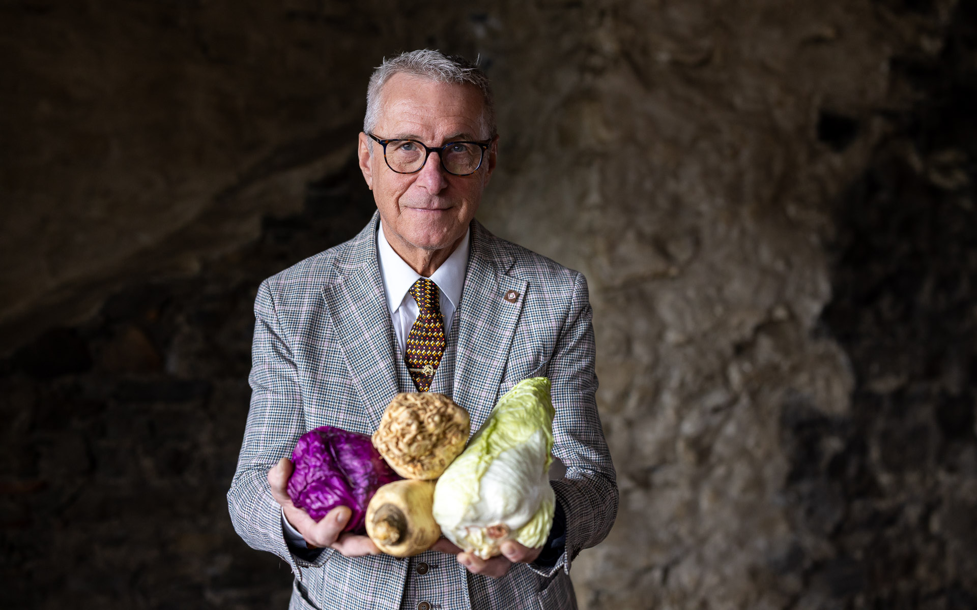 Portrait-Foto von Karl Kranawetter mit Gemüse in der Hand
